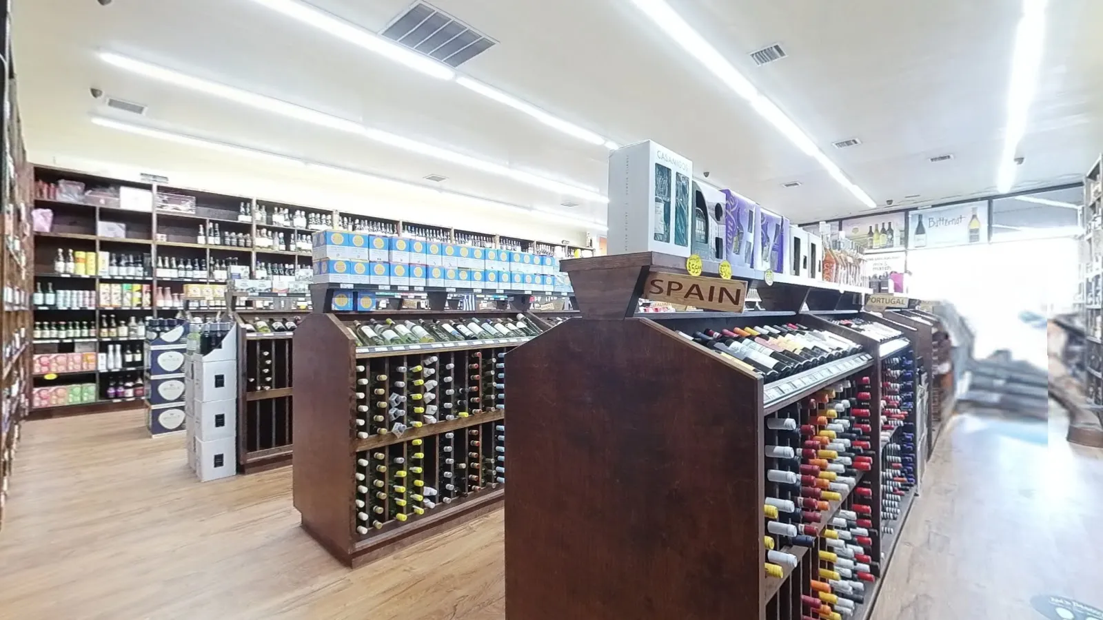 Wine racks and a Spain display inside Lake Success Wine & Liquors